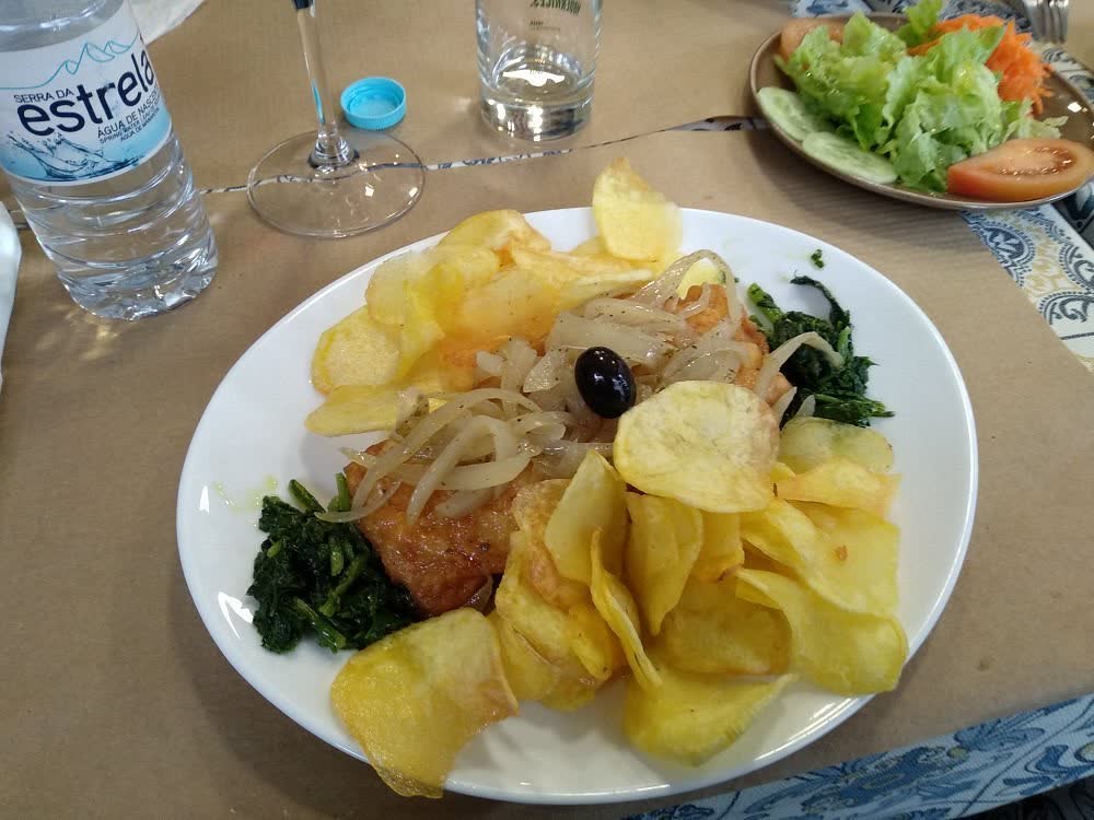 Bacalhau servido à mesa com salada