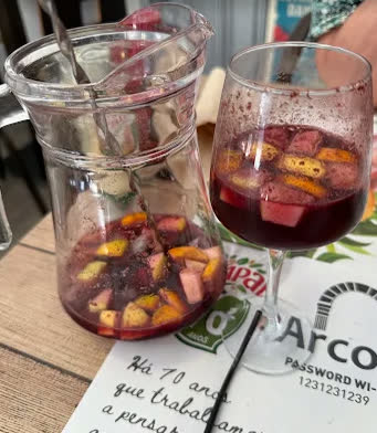 Jarra de sangria com fruta e um copo cheio